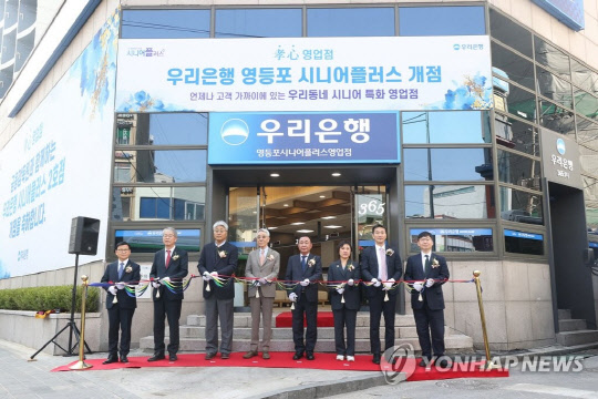 30일 오전 서울 영등포구 우리은행 영등포 시니어플러스점에서 열린 개점식에서 참석자들이 기념촬영하고 있다.  왼쪽부터 이원덕 우리은행장, 임종룡 우리금융그룹 회장, 고객대표 김진호, 장용훈, 김영복, 소희형, 이복현 금감원장, 김영주 금감원 부원장보.  연합뉴스